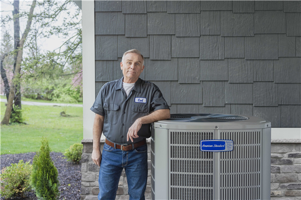 Outdoor AC unit installed next to gray home siding