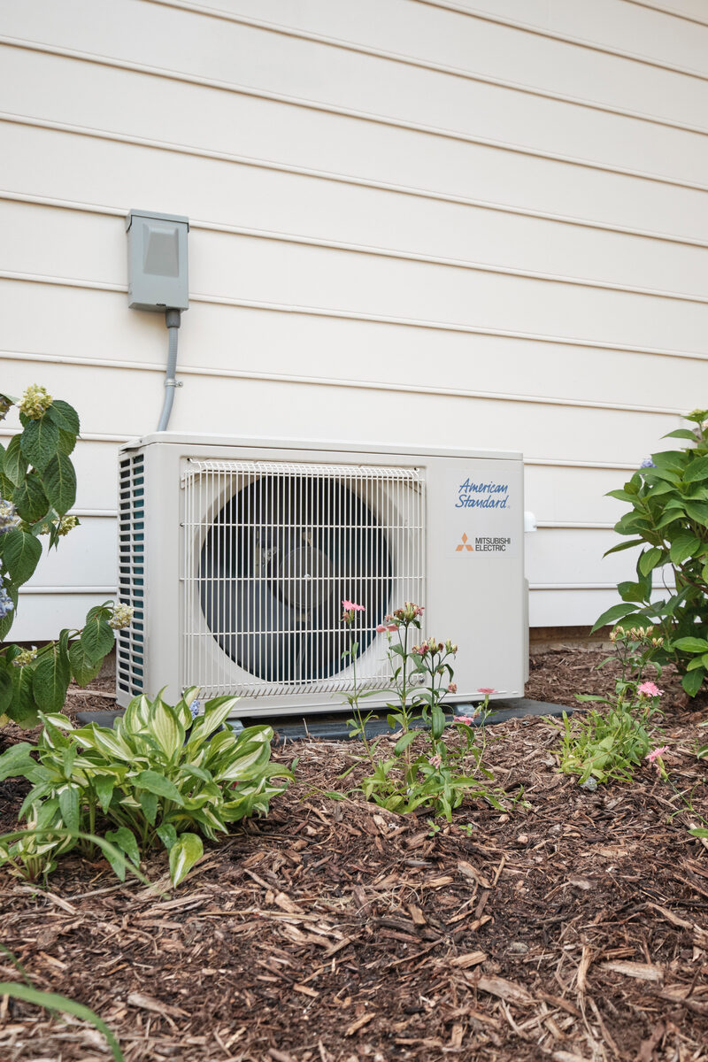Outdoor residential HVAC unit beside a home