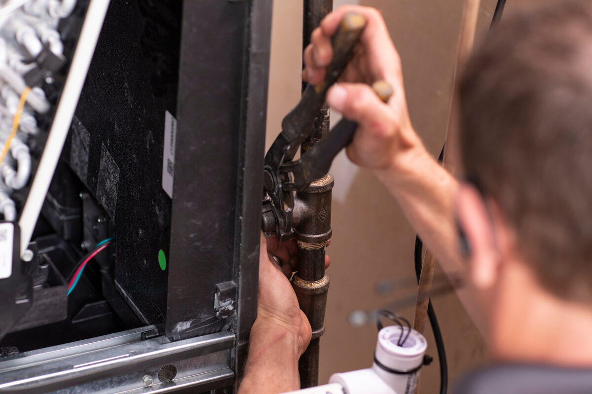 Homeowner adjusting a heat pump on the wall