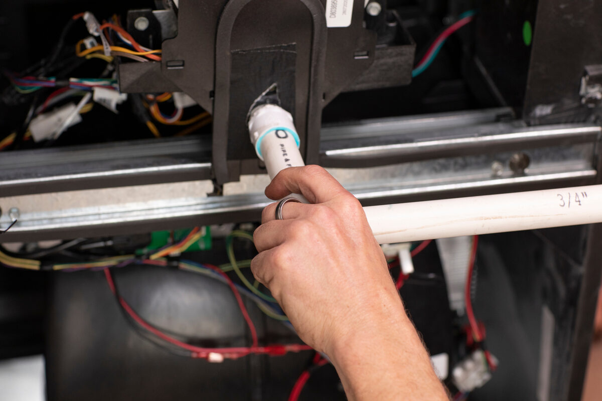 Close-up of hands working on HVAC equipment